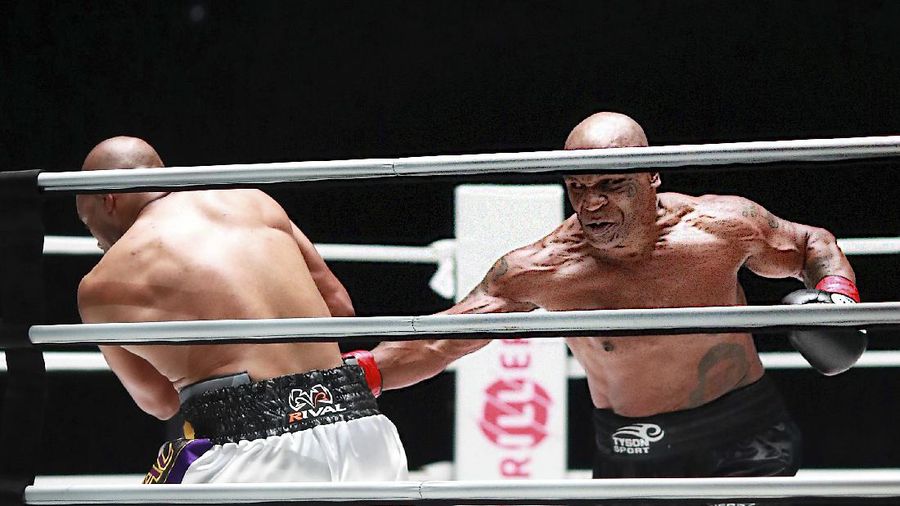 In a photo provided by Triller, Mike Tyson throws a punch during the fourth round against Roy Jones Jr. in an exhibition boxing bout Saturday, Nov. 28, 2020, in Los Angeles. The bout was unofficially ruled a draw by the WBC judges at ringside. Tyson and Jones fought eight two-minute rounds, and both emerged smiling and apparently healthy from a highly unusual event. (Joe Scarnici/Triller via AP)