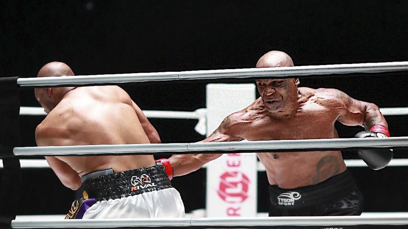 In a photo provided by Triller, Mike Tyson throws a punch during the fourth round against Roy Jones Jr. in an exhibition boxing bout Saturday, Nov. 28, 2020, in Los Angeles. The bout was unofficially ruled a draw by the WBC judges at ringside. Tyson and Jones fought eight two-minute rounds, and both emerged smiling and apparently healthy from a highly unusual event. (Joe Scarnici/Triller via AP)