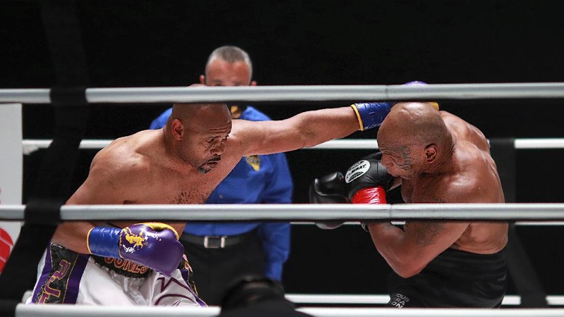 In a photo provided by Triller, Mike Tyson throws a punch during the fourth round against Roy Jones Jr. in an exhibition boxing bout Saturday, Nov. 28, 2020, in Los Angeles. The bout was unofficially ruled a draw by the WBC judges at ringside. Tyson and Jones fought eight two-minute rounds, and both emerged smiling and apparently healthy from a highly unusual event. (Joe Scarnici/Triller via AP)