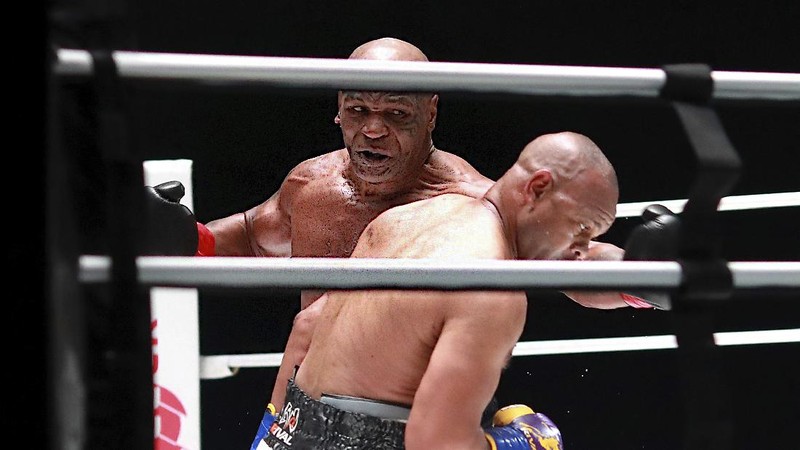 In a photo provided by Triller, Mike Tyson throws a punch during the fourth round against Roy Jones Jr. in an exhibition boxing bout Saturday, Nov. 28, 2020, in Los Angeles. The bout was unofficially ruled a draw by the WBC judges at ringside. Tyson and Jones fought eight two-minute rounds, and both emerged smiling and apparently healthy from a highly unusual event. (Joe Scarnici/Triller via AP)