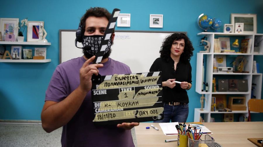 Teacher Rania Koukli prepares to record lessons that are broadcast on public television, at an elementary school in Athens, Wednesday, Nov. 18, 2020. Most other European countries have vowed to keep schools open, but the pandemic has hit Greece hard for the first time in recent weeks following a successful lockdown in the spring, overwhelming hospitals in parts of the country. State television is making and broadcasting lessons, while teachers sit in empty classrooms talking to remote students. Despite some problems, they say it keeps children in touch with their schools. (AP Photo/Thanassis Stavrakis)