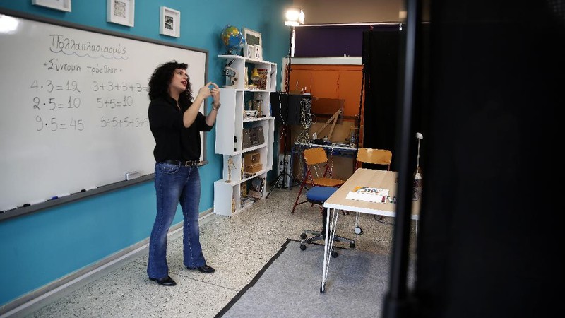 Teacher Rania Koukli prepares to record lessons that are broadcast on public television, at an elementary school in Athens, Wednesday, Nov. 18, 2020. Most other European countries have vowed to keep schools open, but the pandemic has hit Greece hard for the first time in recent weeks following a successful lockdown in the spring, overwhelming hospitals in parts of the country. State television is making and broadcasting lessons, while teachers sit in empty classrooms talking to remote students. Despite some problems, they say it keeps children in touch with their schools. (AP Photo/Thanassis Stavrakis)
