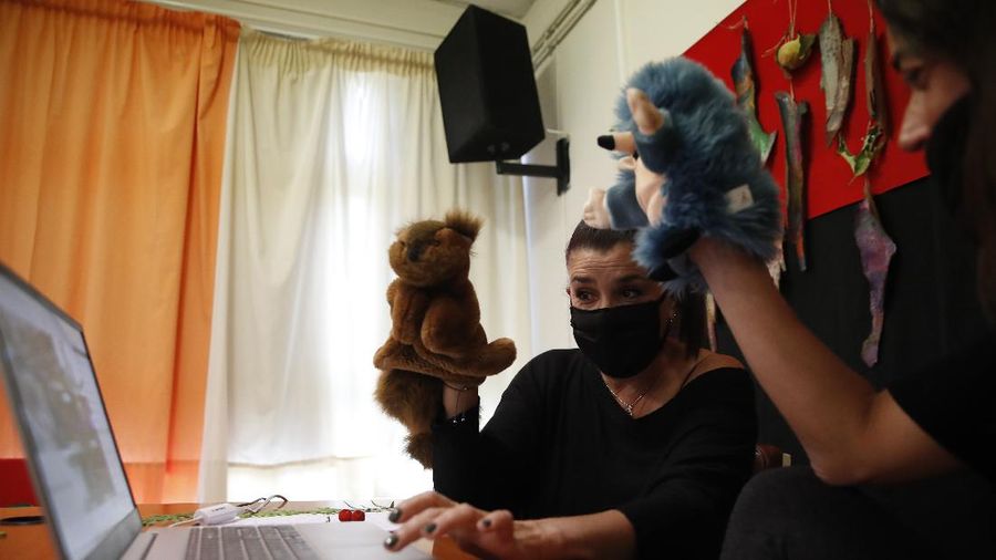 Teacher Rania Koukli prepares to record lessons that are broadcast on public television, at an elementary school in Athens, Wednesday, Nov. 18, 2020. Most other European countries have vowed to keep schools open, but the pandemic has hit Greece hard for the first time in recent weeks following a successful lockdown in the spring, overwhelming hospitals in parts of the country. State television is making and broadcasting lessons, while teachers sit in empty classrooms talking to remote students. Despite some problems, they say it keeps children in touch with their schools. (AP Photo/Thanassis Stavrakis)