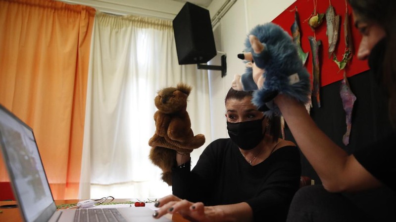 Teacher Rania Koukli prepares to record lessons that are broadcast on public television, at an elementary school in Athens, Wednesday, Nov. 18, 2020. Most other European countries have vowed to keep schools open, but the pandemic has hit Greece hard for the first time in recent weeks following a successful lockdown in the spring, overwhelming hospitals in parts of the country. State television is making and broadcasting lessons, while teachers sit in empty classrooms talking to remote students. Despite some problems, they say it keeps children in touch with their schools. (AP Photo/Thanassis Stavrakis)