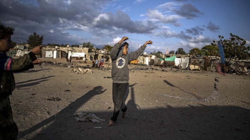 A Palestinian girl walks next to a donkey carte loaded with rocks in a slum on the outskirts of Khan Younis Refugee Camp, in the southern Gaza Strip, Wednesday, Nov. 25, 2020. Israel's blockade of the Hamas-ruled Gaza Strip has cost the seaside territory as much as $16.7 billion in economic losses and caused its poverty and unemployment rates to skyrocket, a U.N. report said Wednesday, as it called on Israel to lift the 13-year closure. (AP Photo/Khalil Hamra)