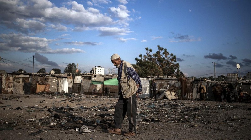 A Palestinian girl walks next to a donkey carte loaded with rocks in a slum on the outskirts of Khan Younis Refugee Camp, in the southern Gaza Strip, Wednesday, Nov. 25, 2020. Israel's blockade of the Hamas-ruled Gaza Strip has cost the seaside territory as much as $16.7 billion in economic losses and caused its poverty and unemployment rates to skyrocket, a U.N. report said Wednesday, as it called on Israel to lift the 13-year closure. (AP Photo/Khalil Hamra)