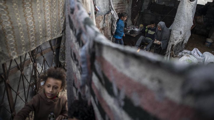 A Palestinian girl walks next to a donkey carte loaded with rocks in a slum on the outskirts of Khan Younis Refugee Camp, in the southern Gaza Strip, Wednesday, Nov. 25, 2020. Israel's blockade of the Hamas-ruled Gaza Strip has cost the seaside territory as much as $16.7 billion in economic losses and caused its poverty and unemployment rates to skyrocket, a U.N. report said Wednesday, as it called on Israel to lift the 13-year closure. (AP Photo/Khalil Hamra)