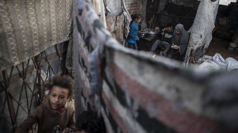 A Palestinian girl walks next to a donkey carte loaded with rocks in a slum on the outskirts of Khan Younis Refugee Camp, in the southern Gaza Strip, Wednesday, Nov. 25, 2020. Israel's blockade of the Hamas-ruled Gaza Strip has cost the seaside territory as much as $16.7 billion in economic losses and caused its poverty and unemployment rates to skyrocket, a U.N. report said Wednesday, as it called on Israel to lift the 13-year closure. (AP Photo/Khalil Hamra)