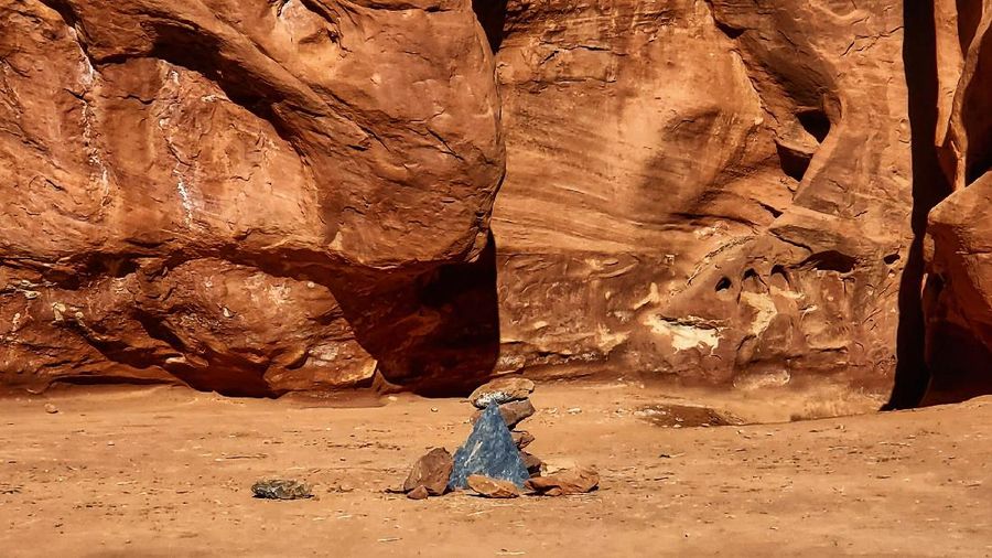 FILE - In this Nov. 18, 2020, file photo provided by the Utah Department of Public Safety, a Utah state worker stands next to a metal monolith in the ground in a remote area of red rock in Utah. The mysterious silver monolith that was placed in the Utah desert has disappeared less than 10 days after it was spotted by wildlife biologists performing a helicopter survey of bighorn sheep, federal officials and witnesses said. The Bureau of Land Management said it had received credible reports that the three-sided stainless steel structure was removed on Nov. 27.  (Utah Department of Public Safety via AP, File)