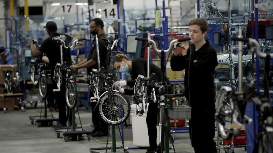 Brompton folding bicycles are assembled by hand at the Brompton factory in west London, Tuesday, Nov. 24, 2020.  The team at Brompton Bicycles company thought they were prepared for Britain's Brexit split with Europe, but they face uncertainty about supplies and unexpected new competition from China, all amid a global COVID pandemic.(AP Photo/Matt Dunham)