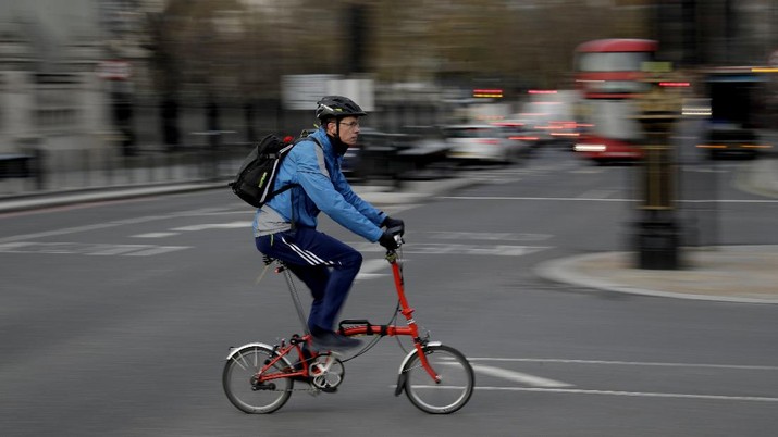 A man cycles on a Brompton folding bicycle in central London, during England's second coronavirus lockdown, Friday, Nov. 20, 2020. The team at Brompton Bicycles company thought they were prepared for Britain's Brexit split with Europe, but they face uncertainty about supplies and unexpected new competition from China, all amid a global COVID pandemic. (AP Photo/Matt Dunham)