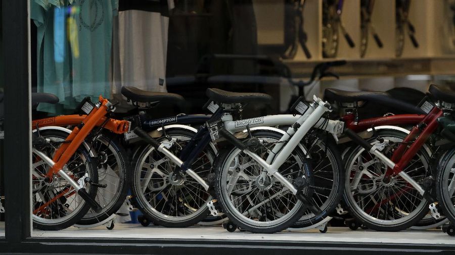 Brompton folding bicycles are displayed in the front window of the brand's store in Covent Garden, central London, during England's second coronavirus lockdown, Friday, Nov. 20, 2020. The team at Brompton Bicycles company thought they were prepared for Britain's Brexit split with Europe, but they face uncertainty about supplies and unexpected new competition from China, all amid a global COVID pandemic. (AP Photo/Matt Dunham)