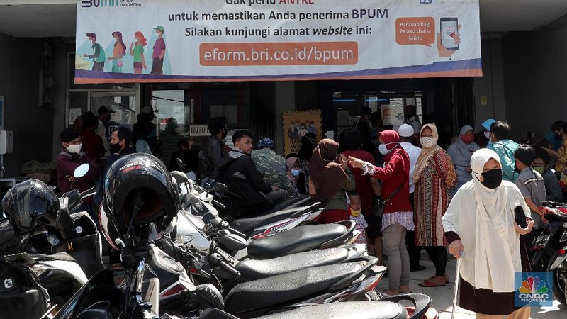 Warga pengantri Bantuan Langsung Tunai (BLT) atau disebut juga Bantuan Presiden Produktif kepada UMKM yang terdampak Covid-19 di kantor Cabang Unit Parung, Bogor, Jawa Barat, Selasa 1/12. Bantuan yang dikelola melalui Kementerian Koperasi dan Usaha Mikro Kecil dan Menengah (Kemenkop dan UKM) senilai Rp 2,4 juta ini disalurkan melalui Bank Rakyat Indonesia (BRI). Pemerintah juga telah menambah target penerima BLT UMKM dari 9 juta usaha menjadi 12 juta. Sejak pagi, sejumlah masyarakat yang merupakan pedagang, pelaku umkm, termasuk ojek online, memadati halaman Kantor Cabang BRI. (CNBC Indonesia/ Muhammad Sabki)
