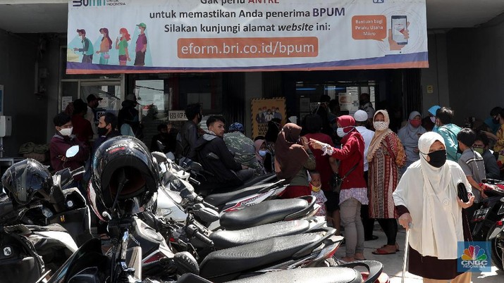 Antrean Warga mencairkan BLT UMKM di Bank BRI Parung Warga pengantri Bantuan Langsung Tunai (BLT) atau disebut juga Bantuan Presiden Produktif kepada UMKM yang terdampak Covid-19 di kantor Cabang Unit Parung, Bogor, Jawa Barat, Selasa 1/12. Bantuan yang dikelola melalui Kementerian Koperasi dan Usaha Mikro Kecil dan Menengah (Kemenkop dan UKM) senilai Rp 2,4 juta ini disalurkan melalui Bank Rakyat Indonesia (BRI). Pemerintah juga telah menambah target penerima BLT UMKM dari 9 juta usaha menjadi 12 juta. Sejak pagi, sejumlah masyarakat yang merupakan pedagang, pelaku umkm, termasuk ojek online, memadati halaman Kantor Cabang BRI. (CNBC Indonesia/ Muhammad Sabki)