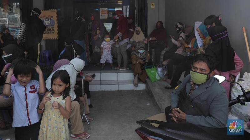 Warga pengantri Bantuan Langsung Tunai (BLT) atau disebut juga Bantuan Presiden Produktif kepada UMKM yang terdampak Covid-19 di kantor Cabang Unit Parung, Bogor, Jawa Barat, Selasa 1/12. Bantuan yang dikelola melalui Kementerian Koperasi dan Usaha Mikro Kecil dan Menengah (Kemenkop dan UKM) senilai Rp 2,4 juta ini disalurkan melalui Bank Rakyat Indonesia (BRI). Pemerintah juga telah menambah target penerima BLT UMKM dari 9 juta usaha menjadi 12 juta. Sejak pagi, sejumlah masyarakat yang merupakan pedagang, pelaku umkm, termasuk ojek online, memadati halaman Kantor Cabang BRI. (CNBC Indonesia/ Muhammad Sabki)