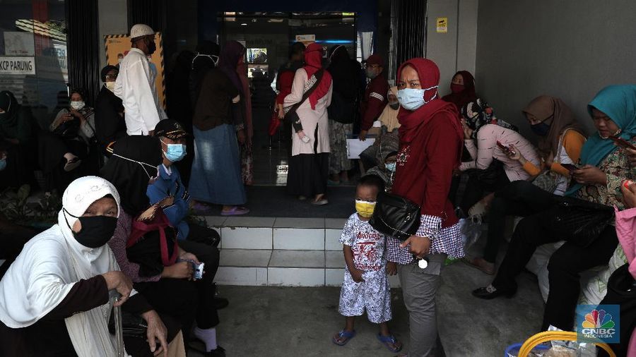 Warga pengantri Bantuan Langsung Tunai (BLT) atau disebut juga Bantuan Presiden Produktif kepada UMKM yang terdampak Covid-19 di kantor Cabang Unit Parung, Bogor, Jawa Barat, Selasa 1/12. Bantuan yang dikelola melalui Kementerian Koperasi dan Usaha Mikro Kecil dan Menengah (Kemenkop dan UKM) senilai Rp 2,4 juta ini disalurkan melalui Bank Rakyat Indonesia (BRI). Pemerintah juga telah menambah target penerima BLT UMKM dari 9 juta usaha menjadi 12 juta. Sejak pagi, sejumlah masyarakat yang merupakan pedagang, pelaku umkm, termasuk ojek online, memadati halaman Kantor Cabang BRI. (CNBC Indonesia/ Muhammad Sabki)