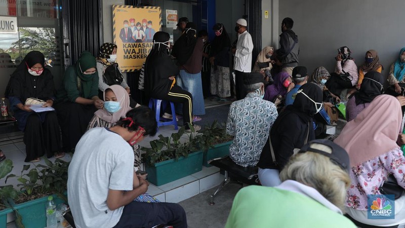 Warga pengantri Bantuan Langsung Tunai (BLT) atau disebut juga Bantuan Presiden Produktif kepada UMKM yang terdampak Covid-19 di kantor Cabang Unit Parung, Bogor, Jawa Barat, Selasa 1/12. Bantuan yang dikelola melalui Kementerian Koperasi dan Usaha Mikro Kecil dan Menengah (Kemenkop dan UKM) senilai Rp 2,4 juta ini disalurkan melalui Bank Rakyat Indonesia (BRI). Pemerintah juga telah menambah target penerima BLT UMKM dari 9 juta usaha menjadi 12 juta. Sejak pagi, sejumlah masyarakat yang merupakan pedagang, pelaku umkm, termasuk ojek online, memadati halaman Kantor Cabang BRI. (CNBC Indonesia/ Muhammad Sabki)