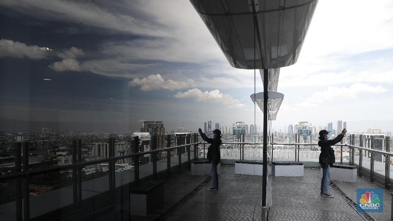 Suasana langit biru di Jakarta terlihat di menara Perpustakaan Nasional, Jakarta, Rabu (2/12). Menurut Badan Meteorologi Klimatologi dan Geofisika (BMKG) Kondisi cuaca yang cerah diakibatkan kelembapan udara yang kering serta angin yang kencang sehingga menghambat pertumbuhan awan hujan dan menyebabkan langit berwarna biru. Berdasarkan data AirVisual dan AirNow menunjukkan Air Quality Index (AQI) dengan polutan PM 2,5 tingkat konsentrasi mikrometer/m³ membaik dalam tiga hari ke belakang. Penurunan konsentrasi akan membuat langit terlihat cerah. Penurunan polusi udara yang berujung dengan indahnya langit Jakarta sempat terjadi pada awal Juli lalu. BMKG mengatakan penurunan polusi udara yang signifikan setelah beberapa pekan penerapan PSBB di DKI Jakarta akibat pandemi Covid-19. (CNBC Indonesia/ Muhammad Sabki)