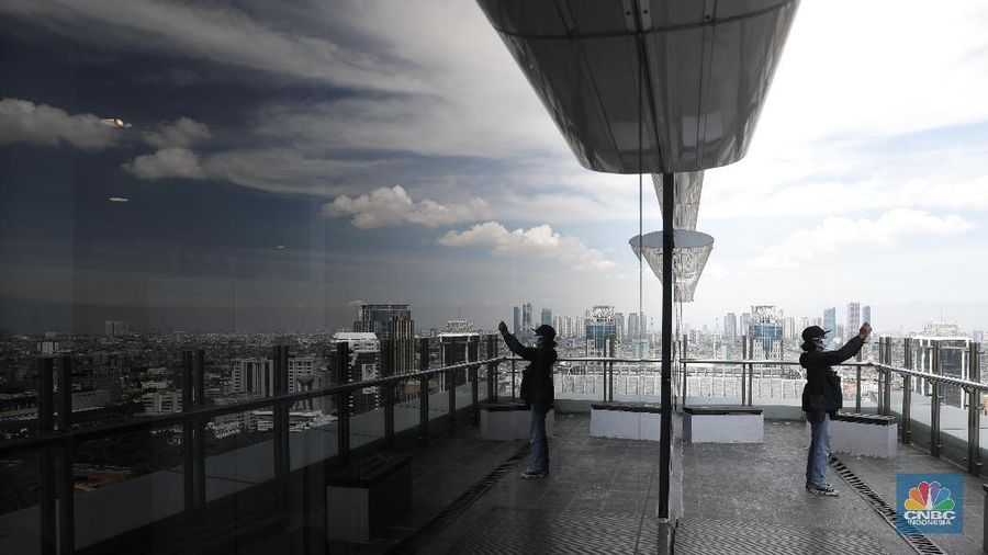 Suasana langit biru di Jakarta terlihat di menara Perpustakaan Nasional, Jakarta, Rabu (2/12). Menurut Badan Meteorologi Klimatologi dan Geofisika (BMKG) Kondisi cuaca yang cerah diakibatkan kelembapan udara yang kering serta angin yang kencang sehingga menghambat pertumbuhan awan hujan dan menyebabkan langit berwarna biru. Berdasarkan data AirVisual dan AirNow menunjukkan Air Quality Index (AQI) dengan polutan PM 2,5 tingkat konsentrasi mikrometer/m³ membaik dalam tiga hari ke belakang. Penurunan konsentrasi akan membuat langit terlihat cerah. Penurunan polusi udara yang berujung dengan indahnya langit Jakarta sempat terjadi pada awal Juli lalu. BMKG mengatakan penurunan polusi udara yang signifikan setelah beberapa pekan penerapan PSBB di DKI Jakarta akibat pandemi Covid-19. (CNBC Indonesia/ Muhammad Sabki)