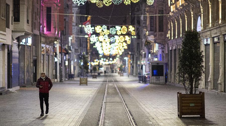 People walk in Istanbul, backdropped by the Galata Tower, during a curfew Tuesday, Dec. 1, 2020, part of the new measures to try curb the spread of the coronavirus. Turkey had gone into the most widespread lockdown so far amid a surge in COVID-19 infections, extending curfews to weeknights and full lockdowns over weekends. The curfew would be implemented on weekdays between 9:00 pm and 5:00 am. He also announced total weekend lockdowns from 9:00 pm on Friday evenings to 5:00 am Monday. (AP Photo)