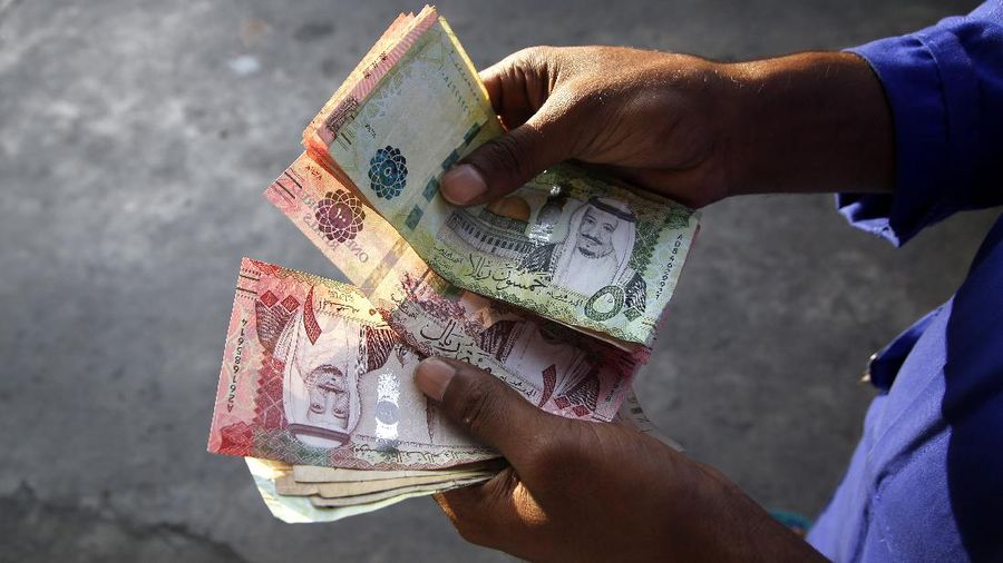 A station attendant counts Saudi Riyal cash as he waits for customers at a gas station in Jiddah, Saudi Arabia, Wednesday, Nov. 13, 2019. (AP Photo/Amr Nabil)