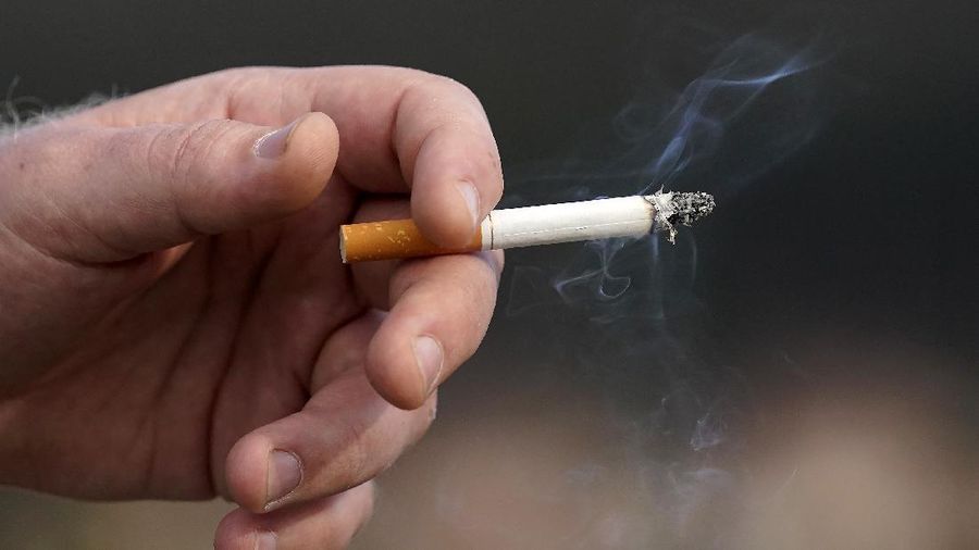 A man who did not want to be identified holds a lit cigarette while smoking in San Francisco, Wednesday, Dec. 2, 2020. City officials in San Francisco have voted to ban all tobacco smoking inside apartments, citing concerns about secondhand smoke. The Board of Supervisors voted 10-1 Tuesday, Dec. 1, 2020, to approve the ordinance making San Francisco the largest city in the country to ban tobacco smoking inside apartments, the San Francisco Chronicle reported. (AP Photo/Jeff Chiu)