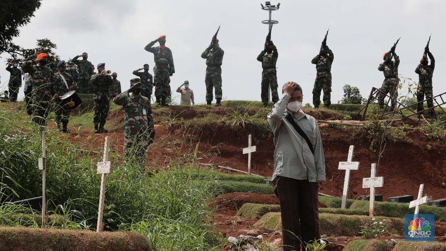 Suasana upacara pemakaman jenazah COVID-19 dengan upacara militer di kawasan TPU Pondok Ranggon Blok Unit Kristen, Jakarta Timur, Kamis (3/12/2020). Lahan khusus untuk jenazah COVID-19 muslim di TPU Pondok Ranggon, Jakarta Timur, penuh. Karena itu, TPU Pondok Ranggon memutuskan hanya melayani jenazah COVID-19 muslim dengan sistem tumpang. Dikutip dari Detikcom 
