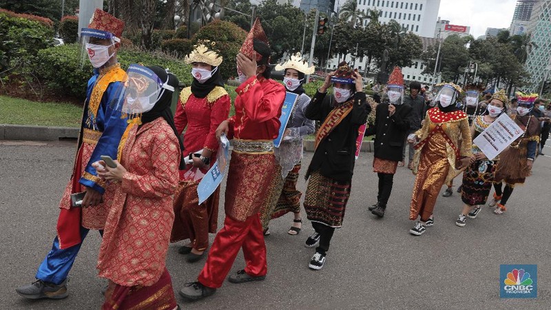Aksi warga mengenakan pakaian adat menyerukan ajakan patuhi aturan Covid-19 saat Pilkada berlangsung disejumlah daerah di Kawasan Patung Kuda Monas, Jakarta, Senin 7/12. (CNBC Indonesia/Muhammad Sabki)