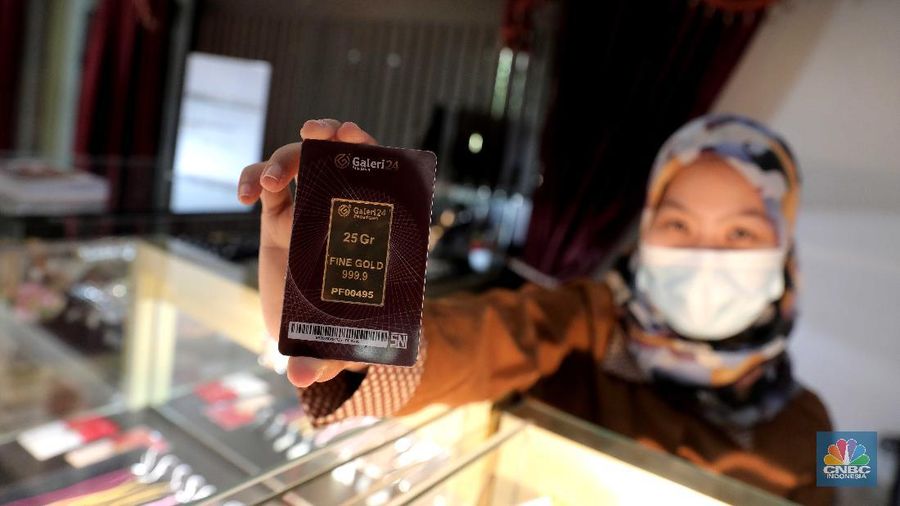 Petugas menunjukkan emas batangan di sebuah gerai emas di Pegadaian, Jakarta. (CNBC Indonesia/Muhammad Sabki)