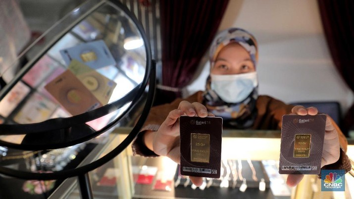 Petugas menunjukkan emas batangan di sebuah gerai emas di Pegadaian, Jakarta. (CNBC Indonesia/Muhammad Sabki)