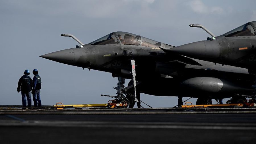 Crewmen of French aircraft carrier Charles de Gaulle stand on deck next of Rafale fighter jets, off the coast of the city of Hyeres, southern France, Thursday, Jan. 23, 2020. France deploys the Charles de Gaulle aircraft carrier for a three-month mission to support International military operations in the Middle East, French President Emmanuel Macron said. (Philippe Lopez/Pool Photo via AP)