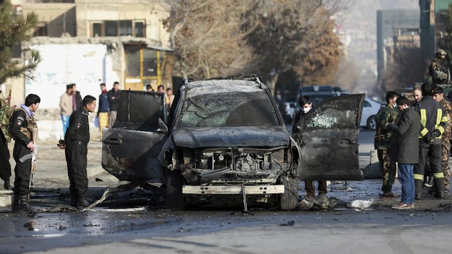 Afghan municipality workers clean the remains of a vehicle after a bomb blast in Kabul, Afghanistan, Sunday, Dec. 13, 2020. A sticky bomb attached to an armored vehicle in northern Kabul killed a few, and wounded at least a few others, according to Ferdaws Faramarz, a spokesman for the Kabul police chief. No further details were immediately available.(AP Photo/Rahmat Gul)