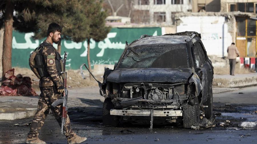Afghan municipality workers clean the remains of a vehicle after a bomb blast in Kabul, Afghanistan, Sunday, Dec. 13, 2020. A sticky bomb attached to an armored vehicle in northern Kabul killed a few, and wounded at least a few others, according to Ferdaws Faramarz, a spokesman for the Kabul police chief. No further details were immediately available.(AP Photo/Rahmat Gul)