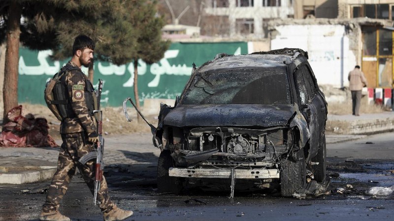 Afghan municipality workers clean the remains of a vehicle after a bomb blast in Kabul, Afghanistan, Sunday, Dec. 13, 2020. A sticky bomb attached to an armored vehicle in northern Kabul killed a few, and wounded at least a few others, according to Ferdaws Faramarz, a spokesman for the Kabul police chief. No further details were immediately available.(AP Photo/Rahmat Gul)