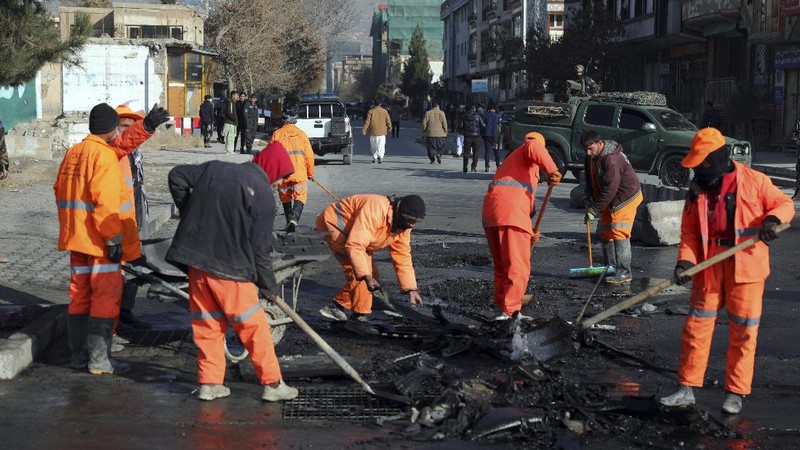 Afghan municipality workers clean the remains of a vehicle after a bomb blast in Kabul, Afghanistan, Sunday, Dec. 13, 2020. A sticky bomb attached to an armored vehicle in northern Kabul killed a few, and wounded at least a few others, according to Ferdaws Faramarz, a spokesman for the Kabul police chief. No further details were immediately available.(AP Photo/Rahmat Gul)