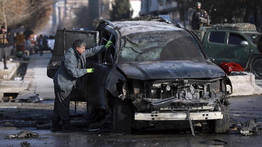 Afghan municipality workers clean the remains of a vehicle after a bomb blast in Kabul, Afghanistan, Sunday, Dec. 13, 2020. A sticky bomb attached to an armored vehicle in northern Kabul killed a few, and wounded at least a few others, according to Ferdaws Faramarz, a spokesman for the Kabul police chief. No further details were immediately available.(AP Photo/Rahmat Gul)