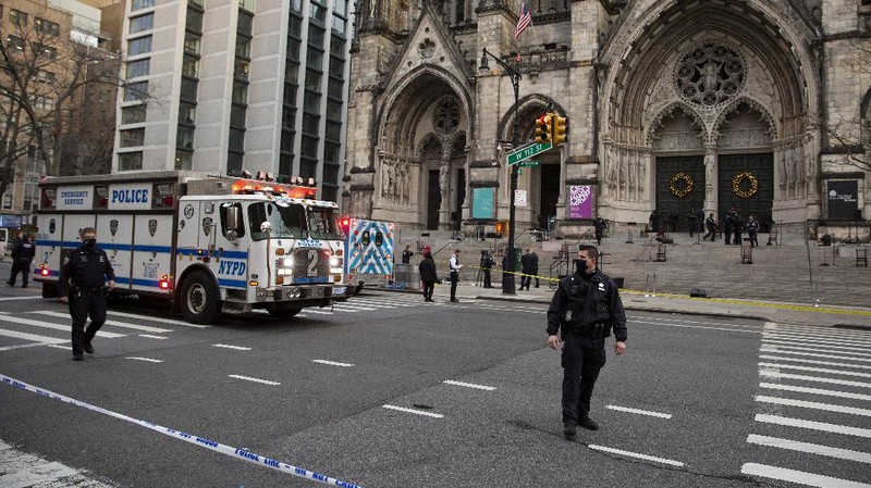 Emergency medical personnel pull a stretcher up to the scene of a shooting at the Cathedral Church of St. John the Divine, Sunday, Dec. 13, 2020, in New York. A man was shot by police after shots rang out at the end of a Christmas choral concert on the steps of the Manhattan cathedral Sunday afternoon. The shooting happened just before 4 p.m. at the church which is the mother church of the Episcopal Diocese of New York and seat of its bishop. (AP Photo/Ted Shaffrey)