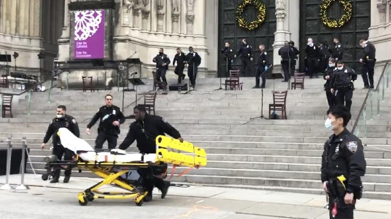 Emergency medical personnel pull a stretcher up to the scene of a shooting at the Cathedral Church of St. John the Divine, Sunday, Dec. 13, 2020, in New York. A man was shot by police after shots rang out at the end of a Christmas choral concert on the steps of the Manhattan cathedral Sunday afternoon. The shooting happened just before 4 p.m. at the church which is the mother church of the Episcopal Diocese of New York and seat of its bishop. (AP Photo/Ted Shaffrey)
