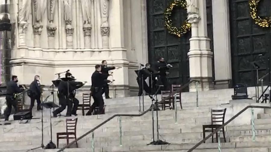 Emergency medical personnel pull a stretcher up to the scene of a shooting at the Cathedral Church of St. John the Divine, Sunday, Dec. 13, 2020, in New York. A man was shot by police after shots rang out at the end of a Christmas choral concert on the steps of the Manhattan cathedral Sunday afternoon. The shooting happened just before 4 p.m. at the church which is the mother church of the Episcopal Diocese of New York and seat of its bishop. (AP Photo/Ted Shaffrey)