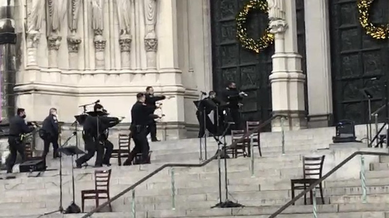 Emergency medical personnel pull a stretcher up to the scene of a shooting at the Cathedral Church of St. John the Divine, Sunday, Dec. 13, 2020, in New York. A man was shot by police after shots rang out at the end of a Christmas choral concert on the steps of the Manhattan cathedral Sunday afternoon. The shooting happened just before 4 p.m. at the church which is the mother church of the Episcopal Diocese of New York and seat of its bishop. (AP Photo/Ted Shaffrey)