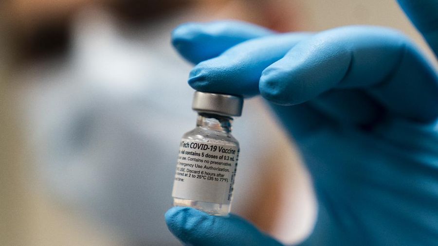 Five doses of the COVID-19 vaccine is held by Spc. Angel Laureano, Monday, Dec. 14, 2020, at the Walter Reed National Military Medical Center in Bethesda Md. (AP Photo/Manuel Balce Ceneta, Pool)