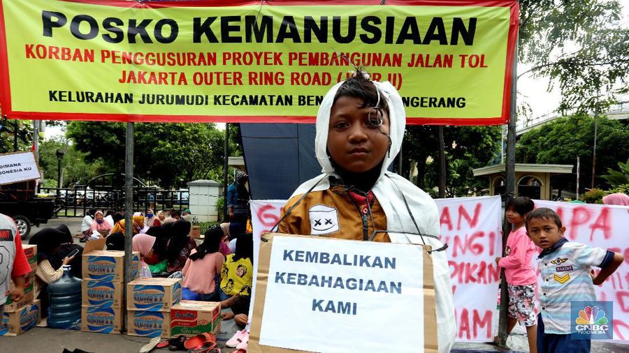 Sejumlah warga terdampak pembangunan Tol JORR II  melakukan aksi dengan mendirikan tenda dan dapur di halaman Gedung Pemerintahan Kota Tangerang, Banten, Selasa (15/12/2020). Aksi tersebut menuntut pemerintahan daerah ikut andil terkait permasalahan uang kompensasi akibat penggusuran untuk proyek pembangunan jalan Tpl JORR II yang dianggap tidak sesuai dengan harapan warga.  (CNBC Indonesia/Tri Susilo)