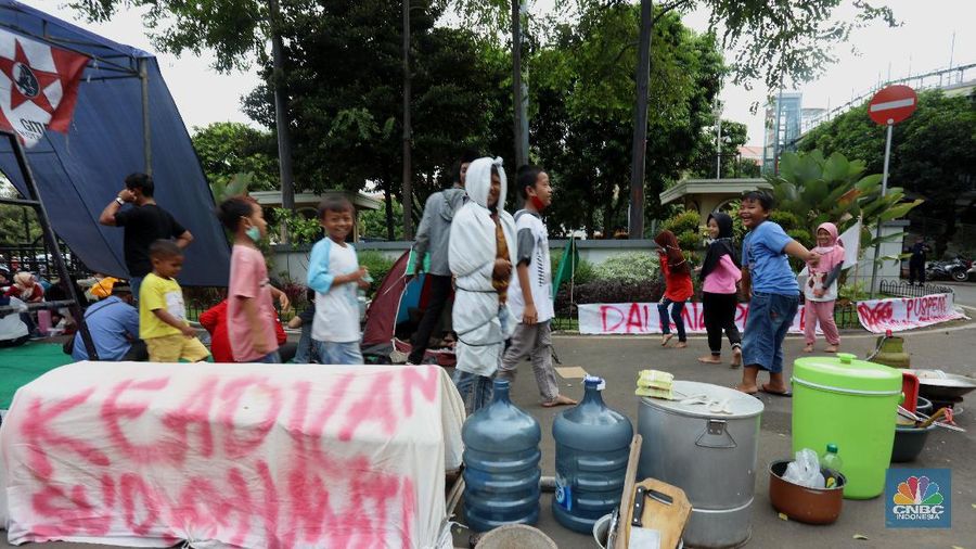 Sejumlah warga terdampak pembangunan Tol JORR II  melakukan aksi dengan mendirikan tenda dan dapur di halaman Gedung Pemerintahan Kota Tangerang, Banten, Selasa (15/12/2020). Aksi tersebut menuntut pemerintahan daerah ikut andil terkait permasalahan uang kompensasi akibat penggusuran untuk proyek pembangunan jalan Tpl JORR II yang dianggap tidak sesuai dengan harapan warga.  (CNBC Indonesia/Tri Susilo)