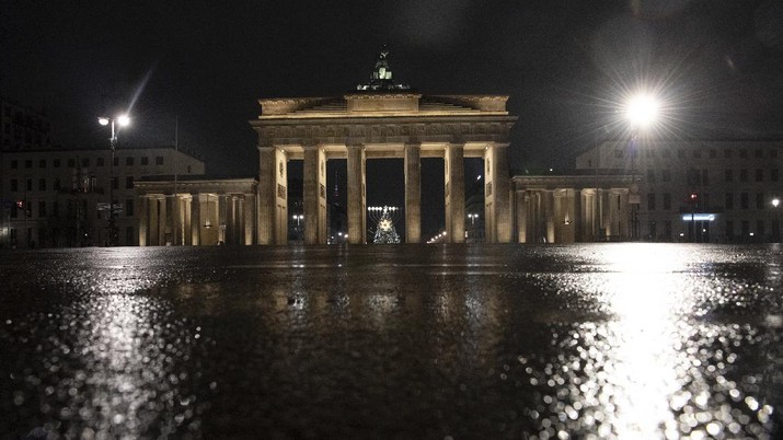 The square in front of the Brandenburg Gate is deserted in Berlin, Germany, early Wednesday, Dec. 16, 2020. In all of Germany, the hard lockdown has begun to slow down the spread of the coronavirus. (Paul Zinken/dpa via AP)