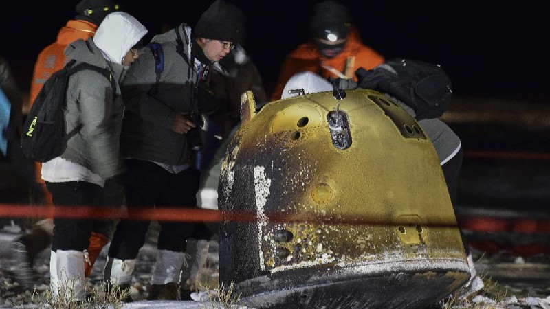 In this photo released by Xinhua News Agency, recovery crew members check on the capsule of the Chang'e 5 probe after its successful landed in Siziwang district, north China's Inner Mongolia Autonomous Region on Thursday, Dec. 17, 2020. A Chinese lunar capsule returned to Earth on Thursday with the first fresh samples of rock and debris from the moon in more than 40 years. (Ren Junchuan/Xinhua via AP)