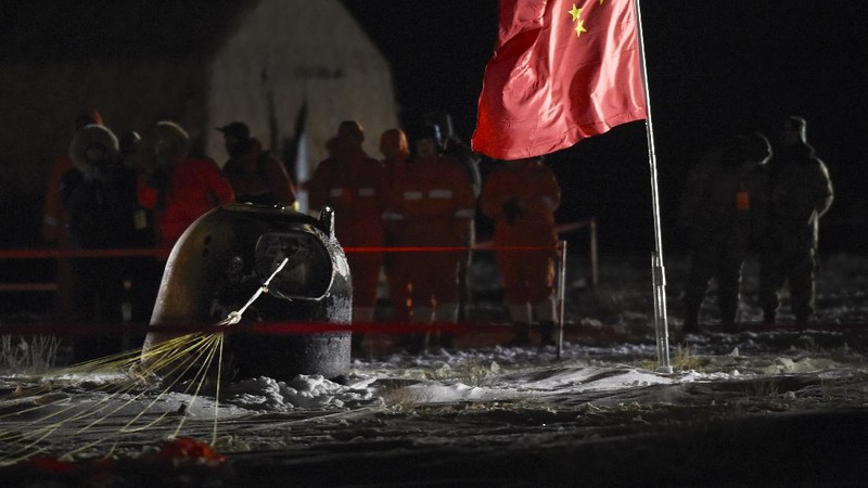 In this photo released by Xinhua News Agency, recovery crew members check on the capsule of the Chang'e 5 probe after its successful landed in Siziwang district, north China's Inner Mongolia Autonomous Region on Thursday, Dec. 17, 2020. A Chinese lunar capsule returned to Earth on Thursday with the first fresh samples of rock and debris from the moon in more than 40 years. (Ren Junchuan/Xinhua via AP)