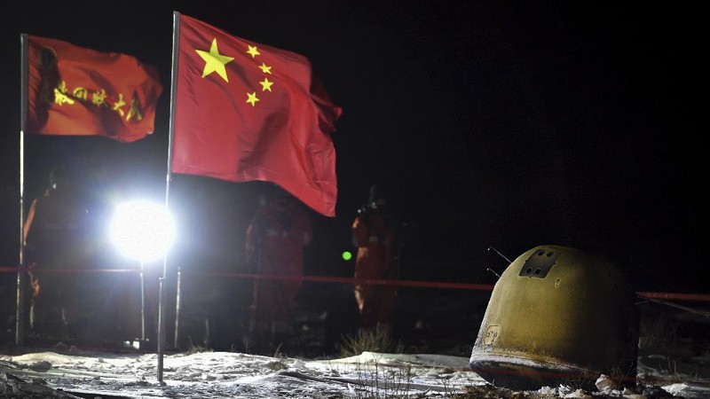 In this photo released by Xinhua News Agency, recovery crew members check on the capsule of the Chang'e 5 probe after its successful landed in Siziwang district, north China's Inner Mongolia Autonomous Region on Thursday, Dec. 17, 2020. A Chinese lunar capsule returned to Earth on Thursday with the first fresh samples of rock and debris from the moon in more than 40 years. (Ren Junchuan/Xinhua via AP)