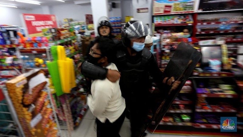 Polisi membubarkan massa aksi 1812 di Abdul Muis, Jakarta Pusat, Jumat (18/12/2020). Petugas pengaman dari satuan Brimob dan Polri memukul mundur aksi massa yang akan menerobos masuk brigader polisi. (CNBC Indonesia/Tri Susilo)