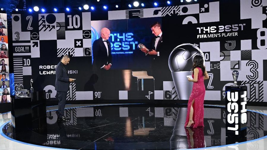 Hosts Reshmin Chowdhury, right, former Dutch soccer player Ruud Gullit, left, announce the best player award to Poland's Robert Lewandowski during the Best FIFA Football Awards Ceremony in Zurich, Switzerland, Thursday, Dec. 17, 2020. (Valeriano Di Domenico/Pool via AP)