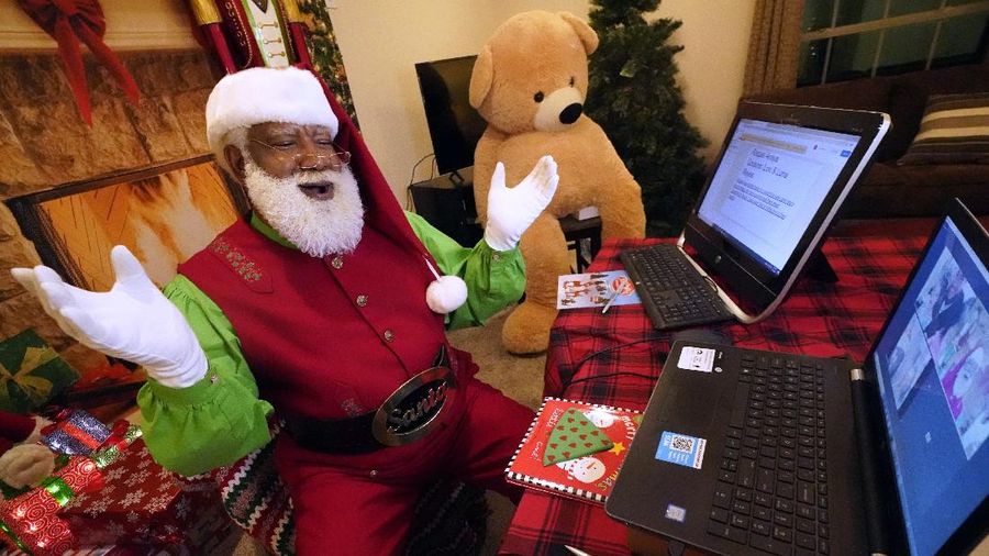 Virus Outbreak Safe Santas Photo Gallery Larry Jefferson portrays Santa Claus and conducts a visit via a computer screen with Raquel Anaya and her cousins Lexi and Luna Reyes from his home in Duncanville, Texas, on Dec. 9, 2020. The children lost a grandmother to COVID-19 recently. In this socially distant holiday season, Santa Claus is still coming to towns (and shopping malls) across America but with a few 2020 rules in effect. (AP Photo/LM Otero)